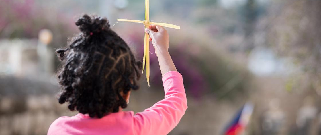 Heiliges Kreuz, Kind hält Strohkreuz gegen den Himmel