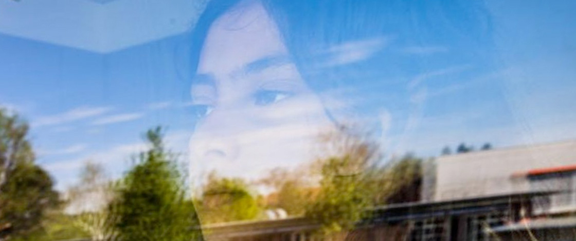 Gesicht eines KIndes in der Spiegelung eines Fensters